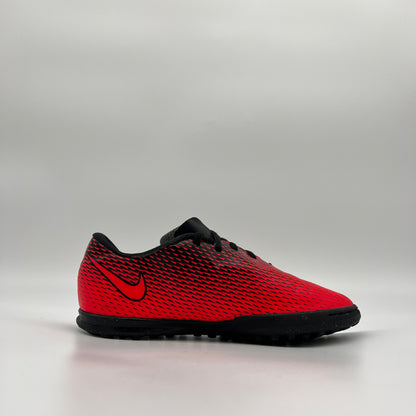 Profile view of a red and black Nike Jr. BravataX II (TF) turf soccer shoe with a black Nike swoosh and a multi-studded rubber outsole for artificial grass
