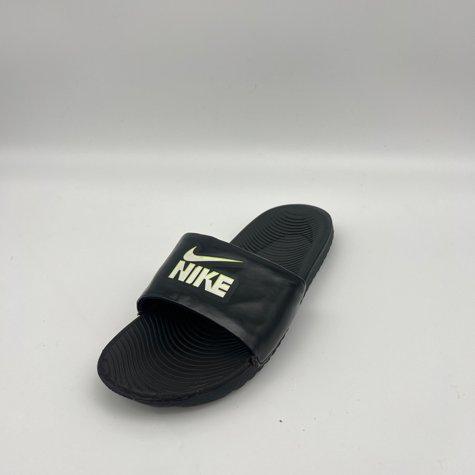 Black Nike slide sandal on a light gray background