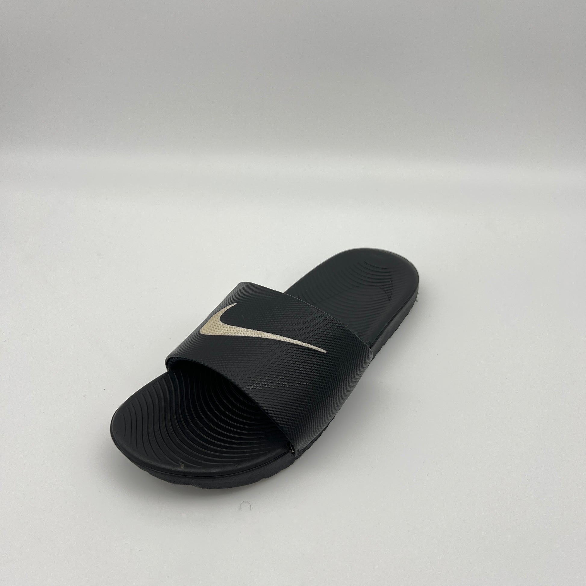 Black slide sandal with a logo on a light gray background