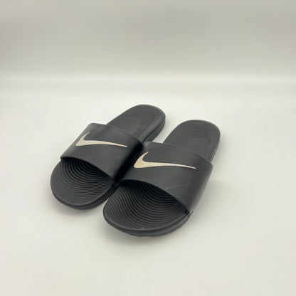 Pair of black slides with Nike logo on a white background