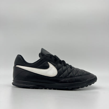 Black Nike Majestry IC indoor soccer shoe with a white swoosh and a classic quilted-style stitched upper on a white background.