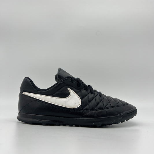 Black Nike Majestry IC indoor soccer shoe with a white swoosh and a classic quilted-style stitched upper on a white background.