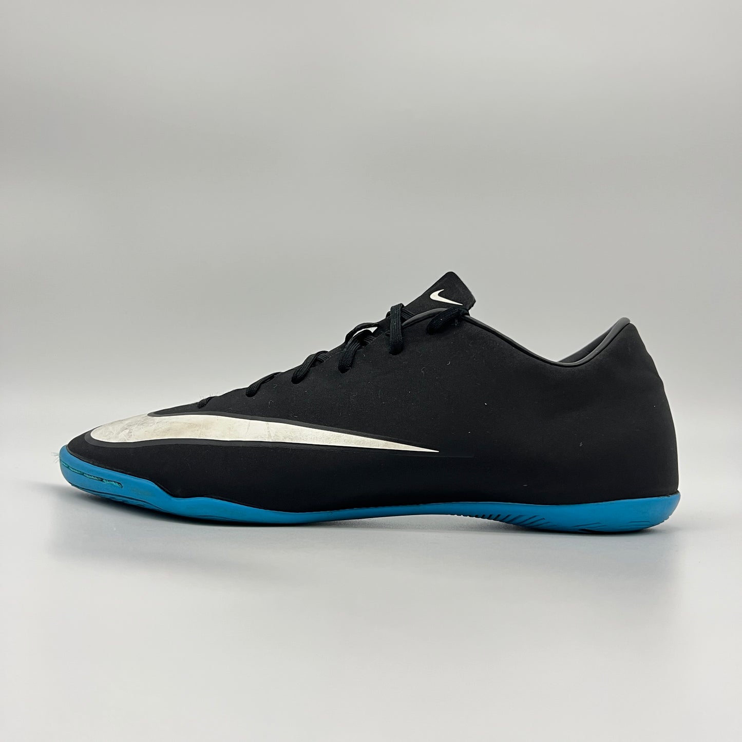 Side view of black Nike Mercurial Victory V CR7 indoor soccer shoe with blue sole.