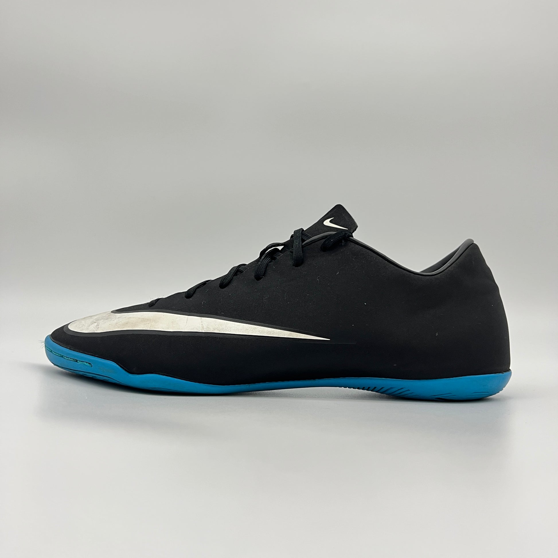 Side view of black Nike Mercurial Victory V CR7 indoor soccer shoe with blue sole.
