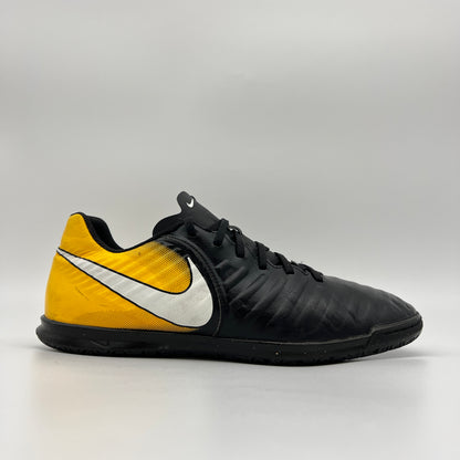 Side profile of a Nike Tiempo Legend VII Academy IC indoor soccer shoe in black and yellow with a white Nike swoosh and flat black rubber sole.