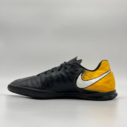 Side profile of a Nike Tiempo Legend VII Academy IC indoor soccer shoe in black and yellow with a white Nike swoosh and flat black rubber sole.