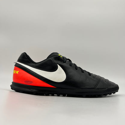 Side view of black Nike TiempoX Rio III TF soccer shoe with white swoosh and orange heel