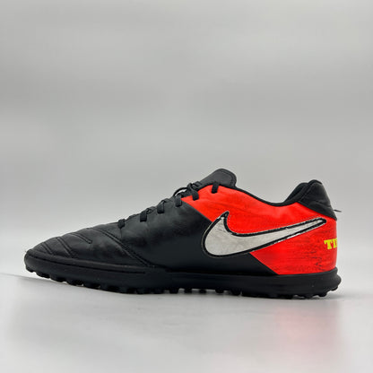 Side view of black Nike TiempoX Rio III TF soccer shoe with white swoosh and orange heel