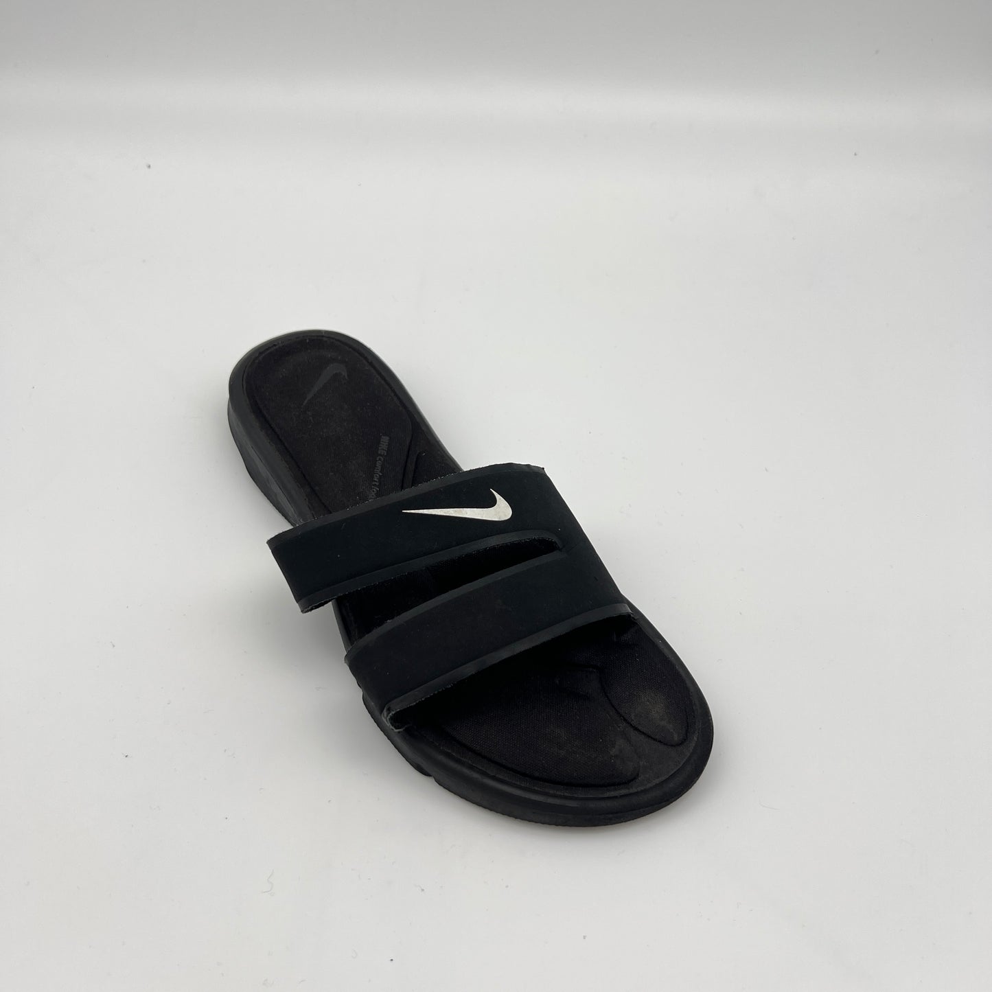 Black slide sandal with Nike logo on a white background