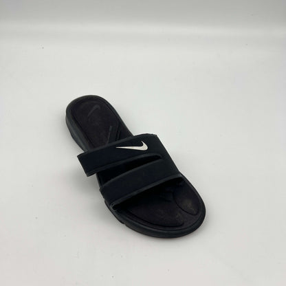 Black slide sandal with Nike logo on a white background