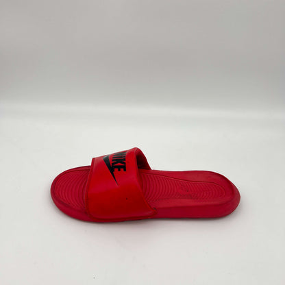  A side profile view of a vibrant University Red Nike Victori One slide with a black Nike logo on a plain white background