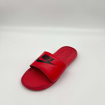 Close-up of the textured, contoured footbed and padded strap of the Nike Victori One slide in red