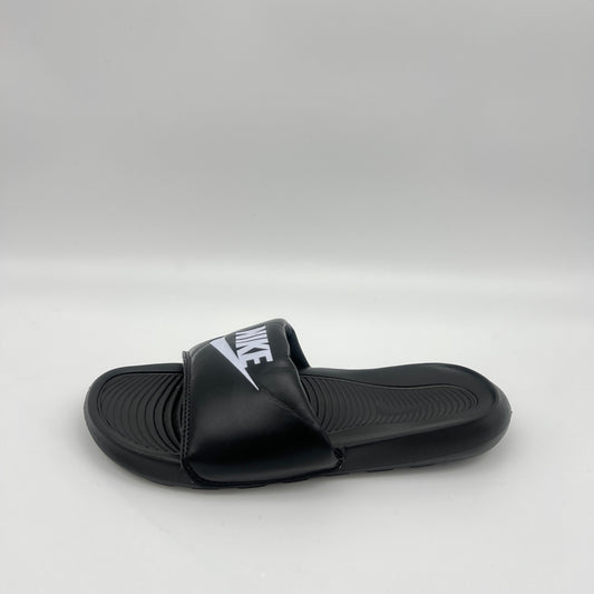 Black slide sandal with Nike logo on a light gray background