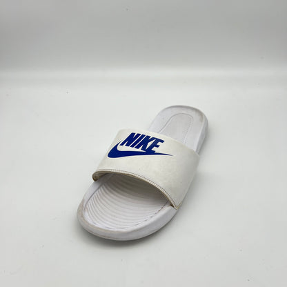 White slide sandal with blue Nike logo on a light gray background