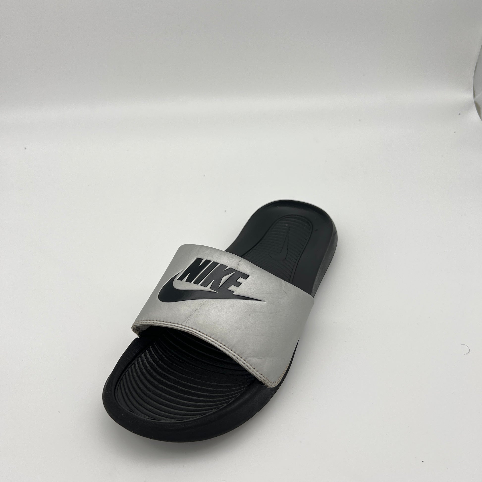 Gray and black slide sandal with Nike logo on a white background
