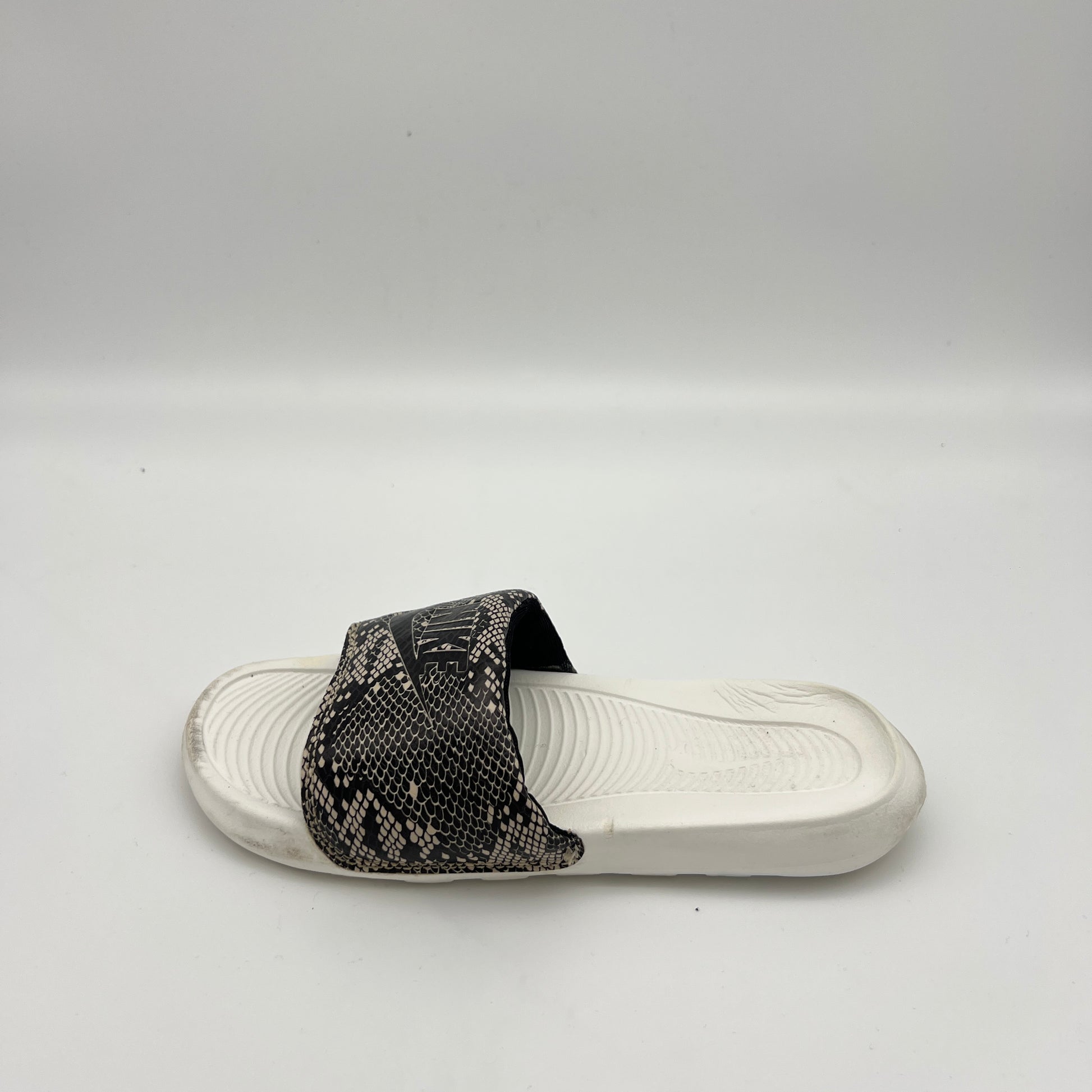 Nike Victori One women's slide sandal with black and white snakeskin print strap on a white footbed.
