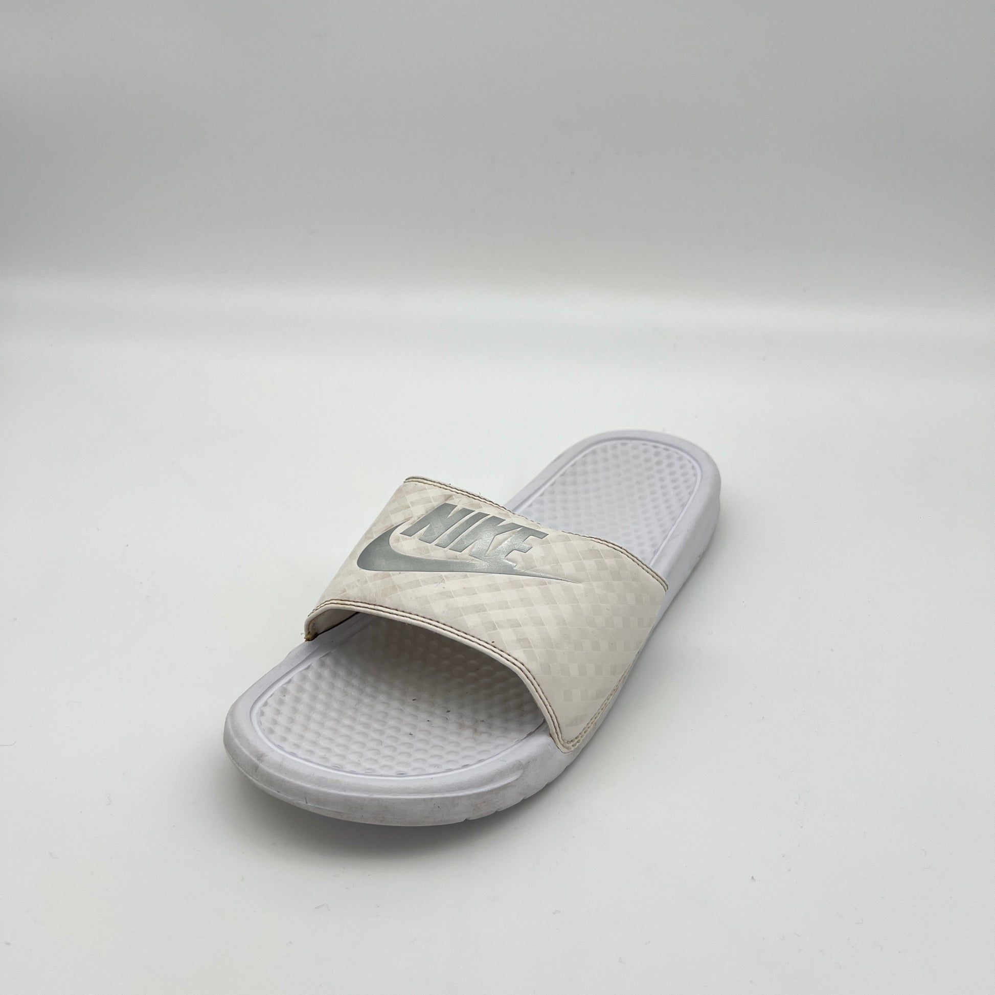 White slide sandal with Nike logo on a light gray background