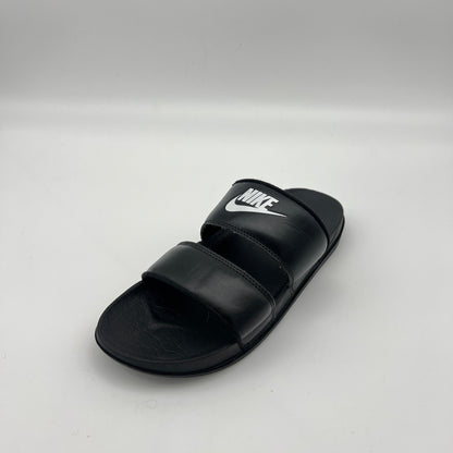 Black Nike sandal on a light gray background
