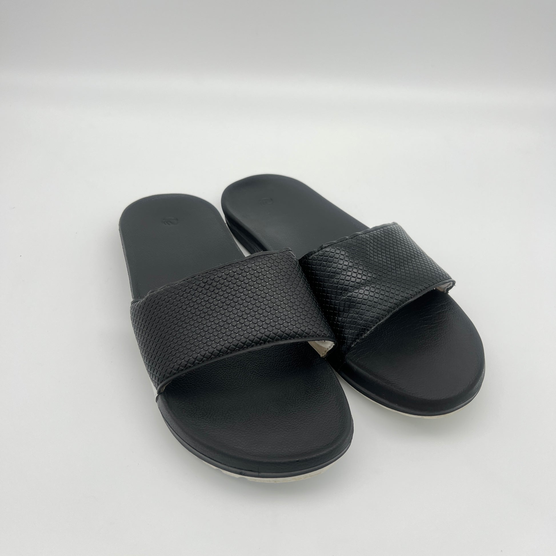 Black slide sandals on a white background