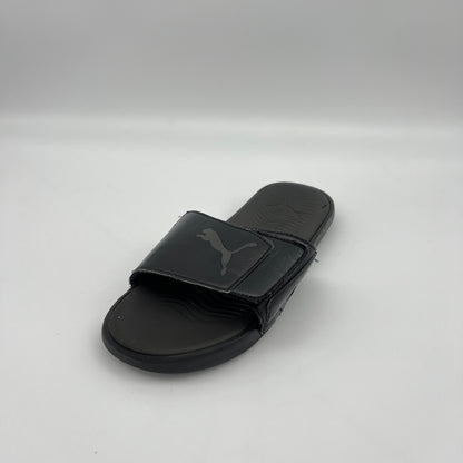 Black slide sandal with Puma logo on a light gray background