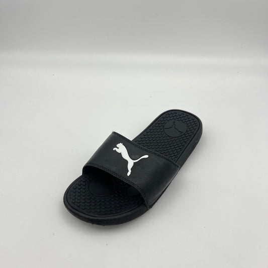 A single black PUMA Cool Cat Sport slide sandal featuring a prominent white jumping cat logo on the strap and a textured footbed on a white background.