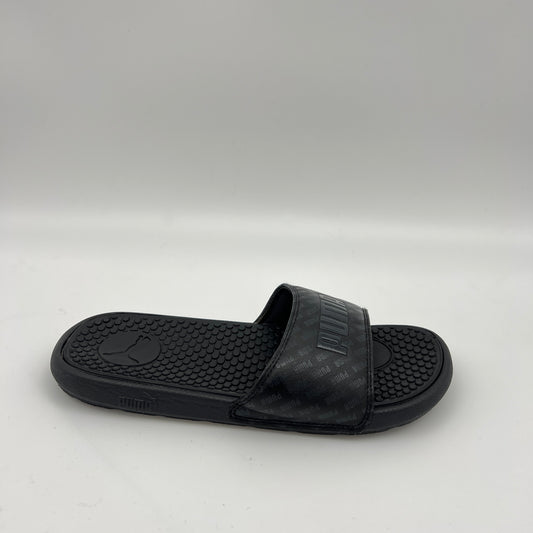 PUMA Cool Cat V slide in black featuring a repeating PUMA logo pattern on the strap and a textured, contoured black footbed.