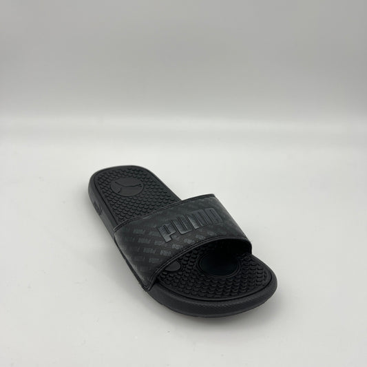 Black slide sandal with Puma logo on a light gray background