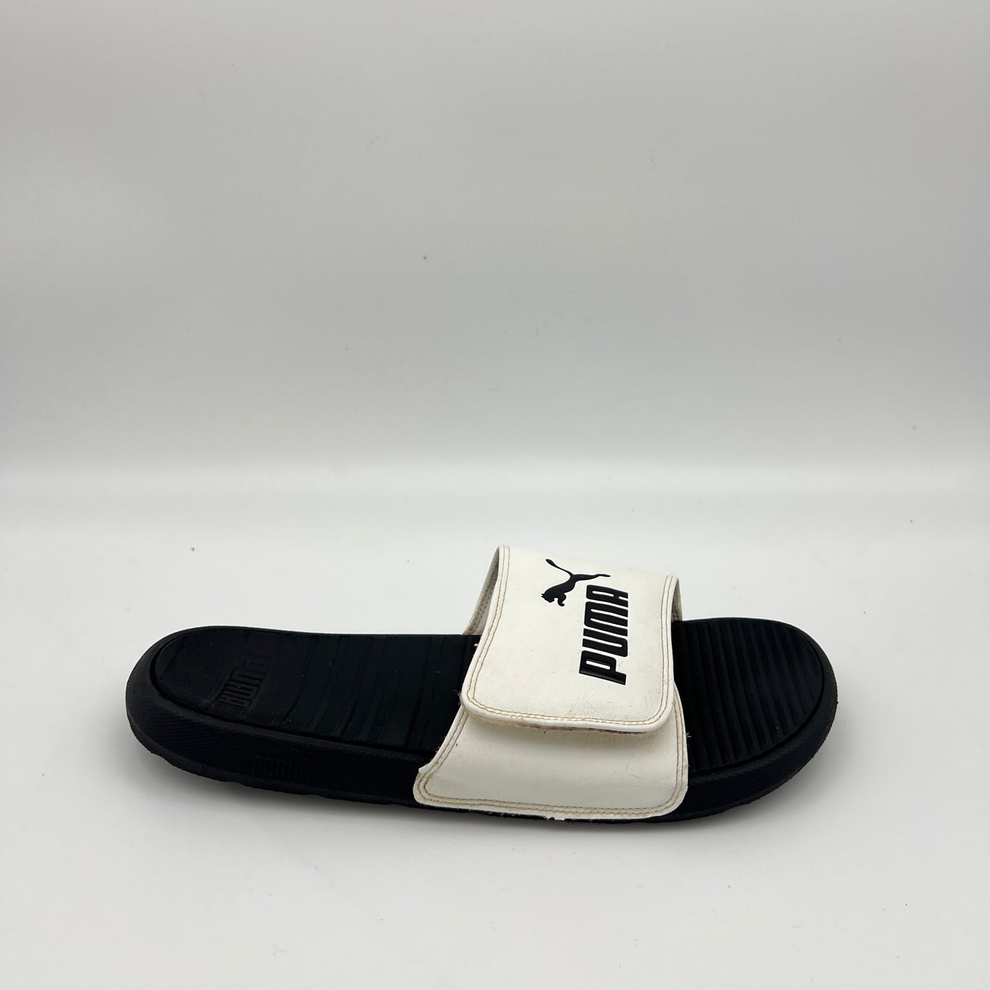 Side view of PUMA Men’s Cool Cat V Sport slide sandal in white and black.