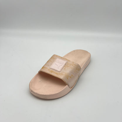 Beige slide sandal with a brand logo on a light gray background