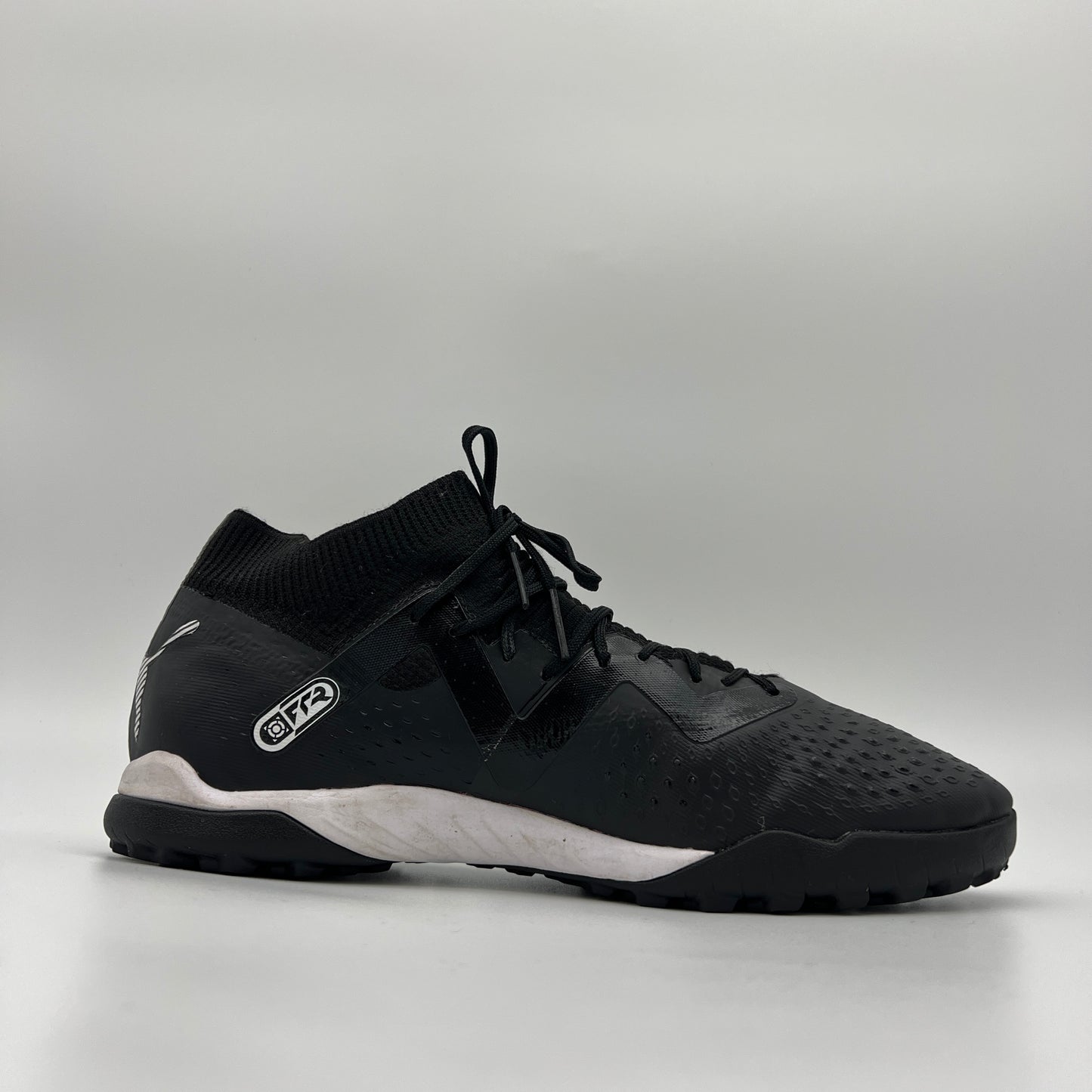 Side view of black mid-cut Puma Future Match TT soccer shoe with white logo.