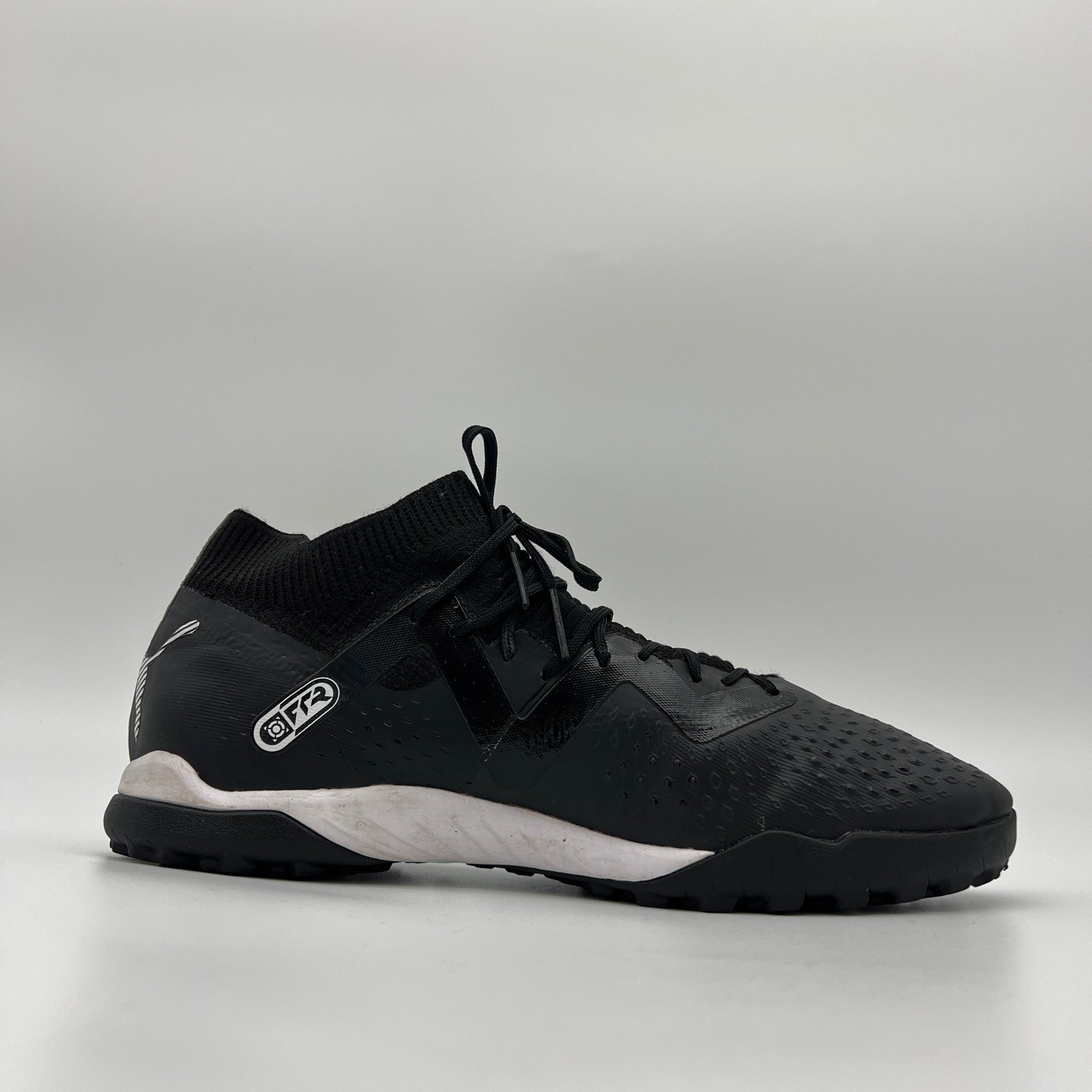 Side view of black mid-cut Puma Future Match TT soccer shoe with white logo.