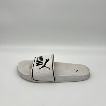 Side view of a white Puma Leadcat 2.0 slide sandal featuring a padded strap with a black Puma cat logo and text, set against a white contoured footbed.