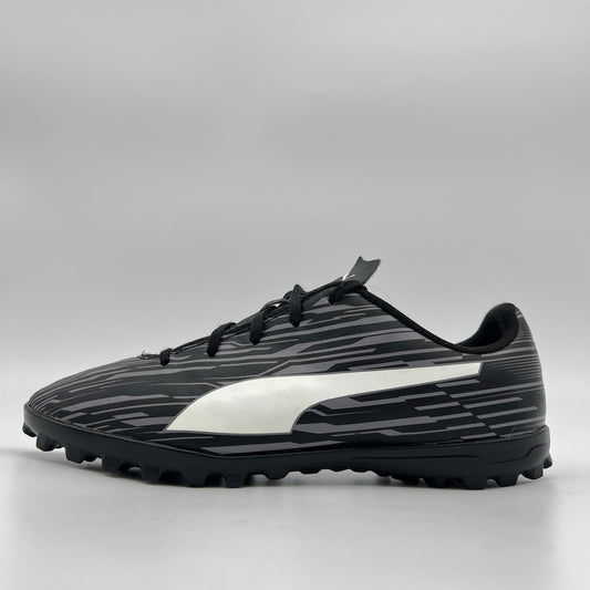 Side profile of a black Puma Rapido III TT soccer shoe featuring a grey-striped graphic pattern, white Puma formstrip, and black turf-ground studs.