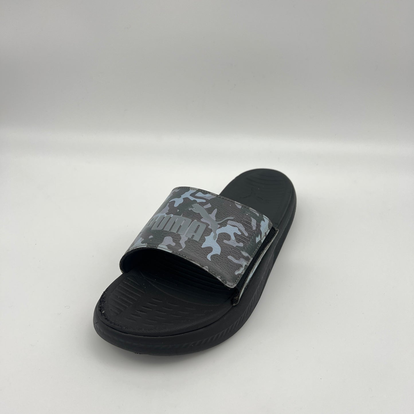 Black slide sandal with camouflage pattern on a white background