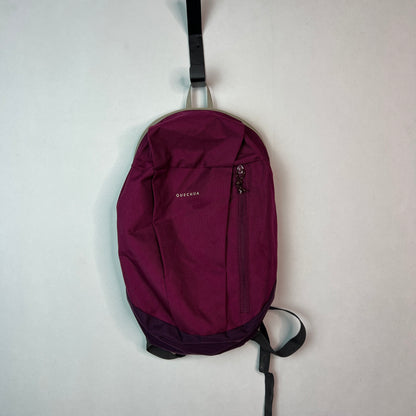 Purple Quechua NH100 10L hiking backpack hanging on a wall hook