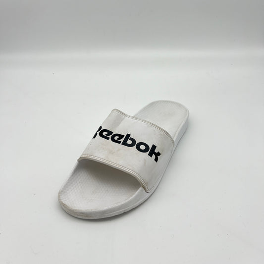White Reebok slide sandal on a light gray background