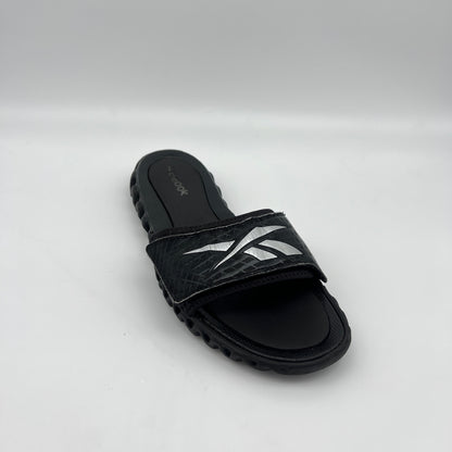 Black sandal with white design on a light gray background