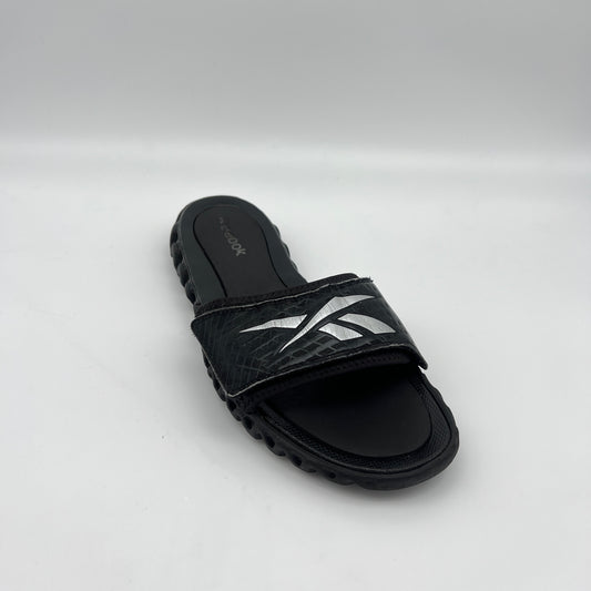 Black sandal with white design on a light gray background