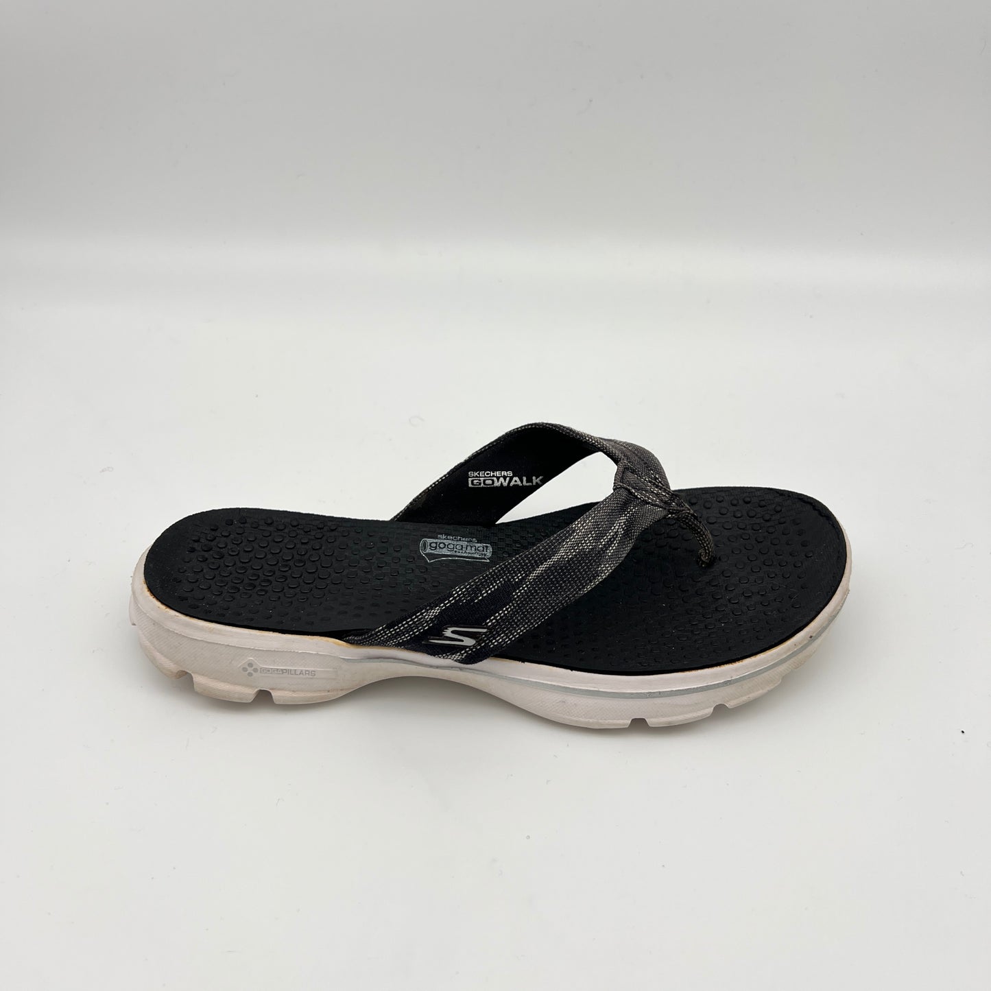 Side view of a black Skechers GOwalk 3 thong-style flip flop with a textured "Goga Mat" footbed, grey patterned fabric straps, and a thick white cushioned sole.
