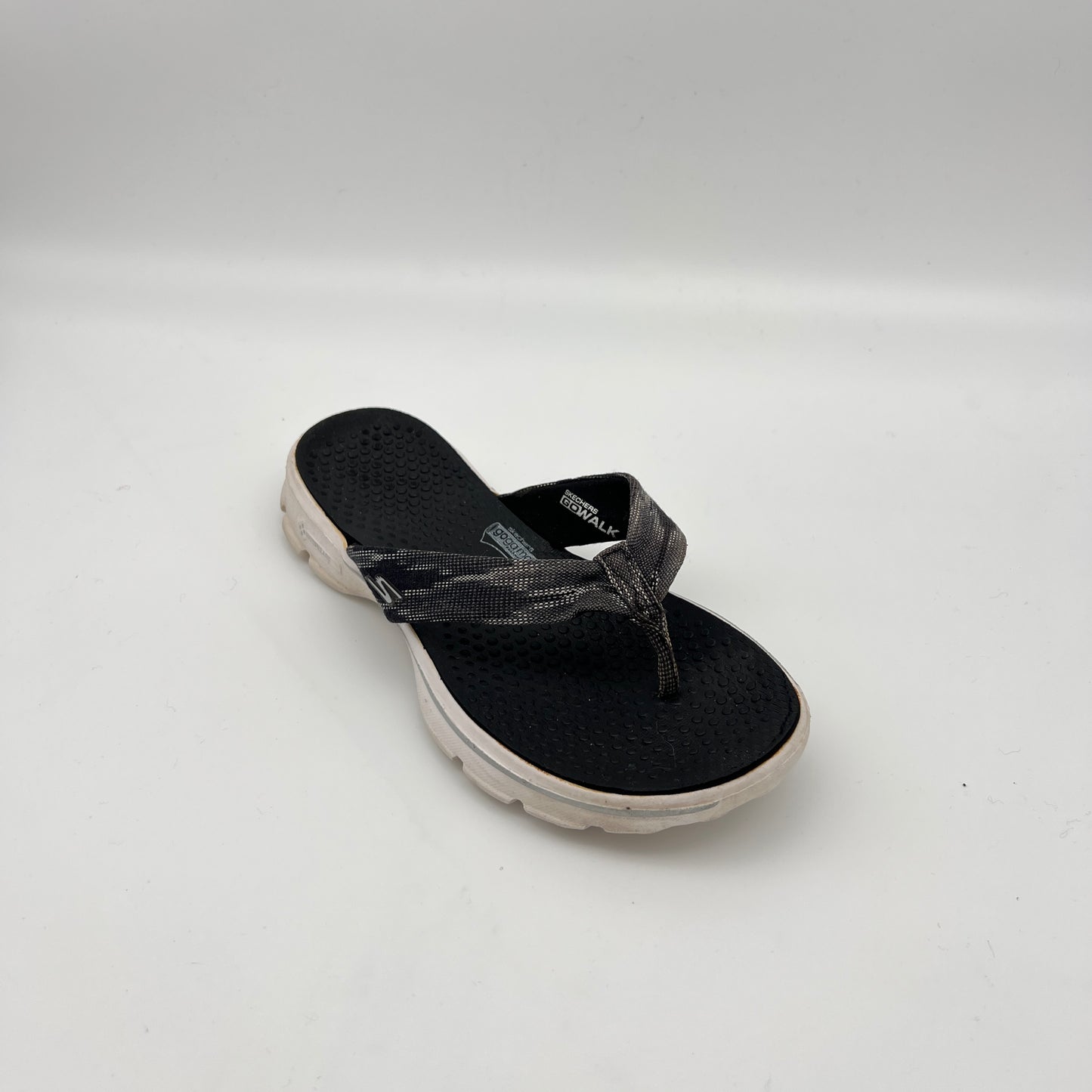 Black sandal with a white sole on a light gray background