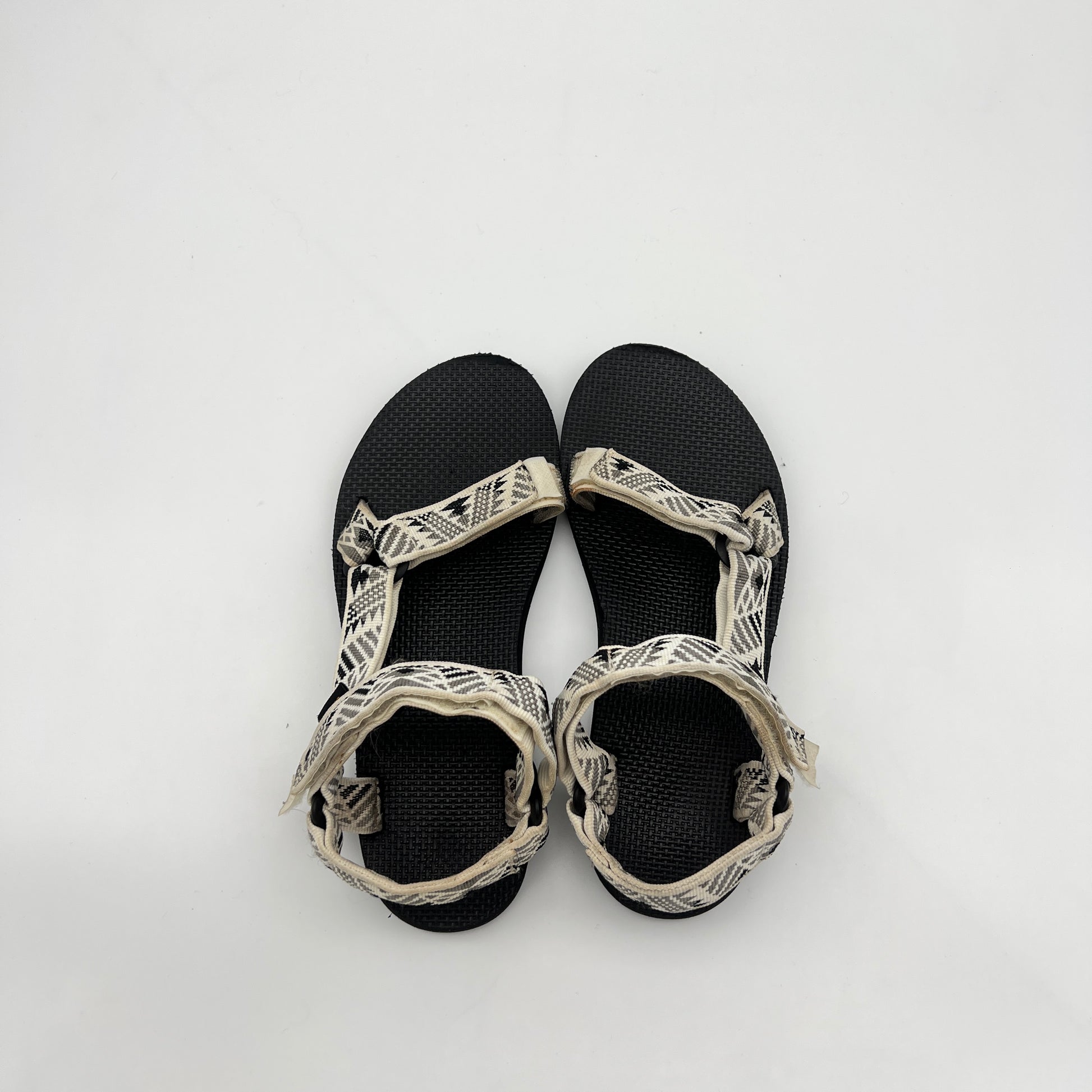 Black sandals with white straps on a white background