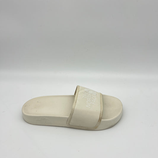 Side view of an off-white The North Face Base Camp Slide III with a textured "THE NORTH FACE" logo on a wide synthetic strap and a contoured cream footbed.
