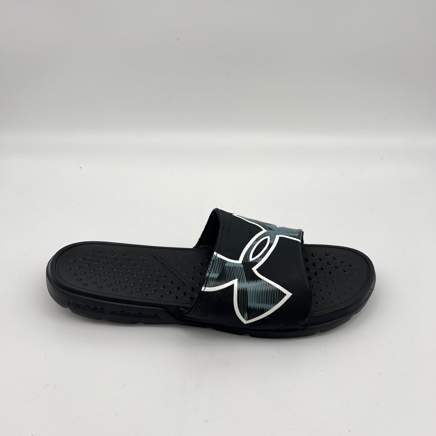 Black Under Armour Ignite Pro men's slide with a white-outlined logo and textured memory foam footbed.