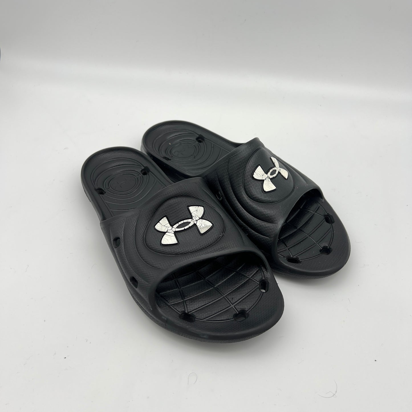 Waterproof men's locker room slides; durable black Under Armour sandals with quick-dry drainage system