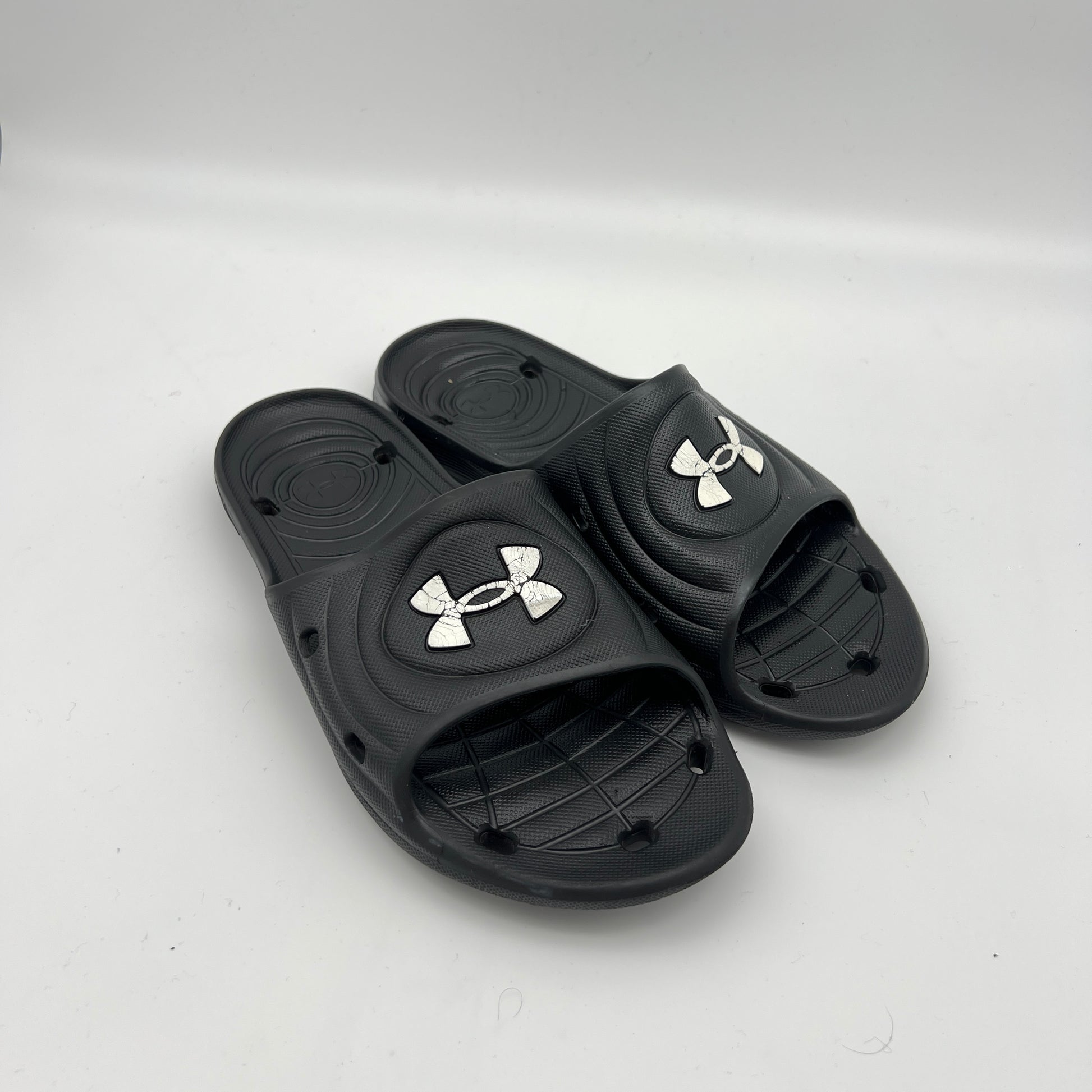Waterproof men's locker room slides; durable black Under Armour sandals with quick-dry drainage system