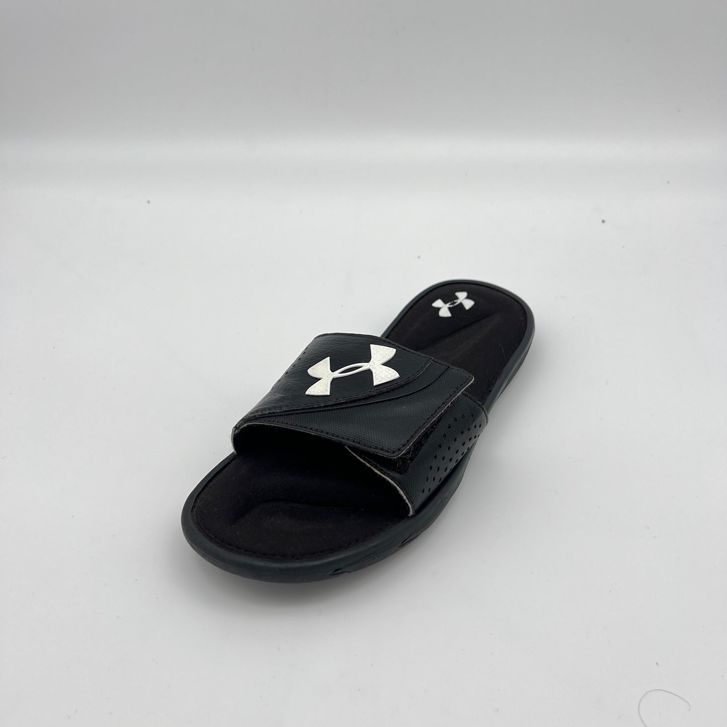 Under Armour athletic slides featuring an adjustable logo strap and plush memory foam cushioning