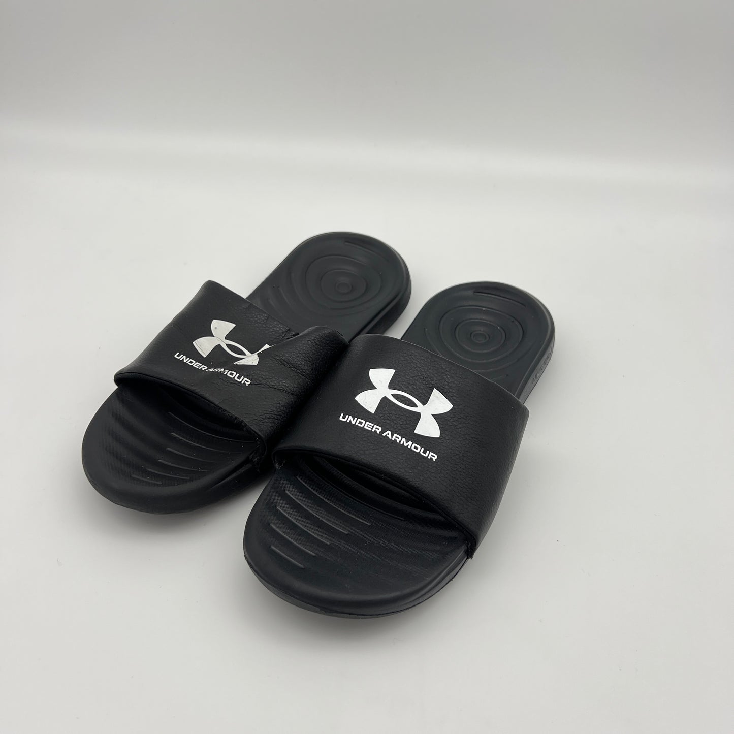 Lightweight black Under Armour sandals with a textured footbed and durable EVA outsole