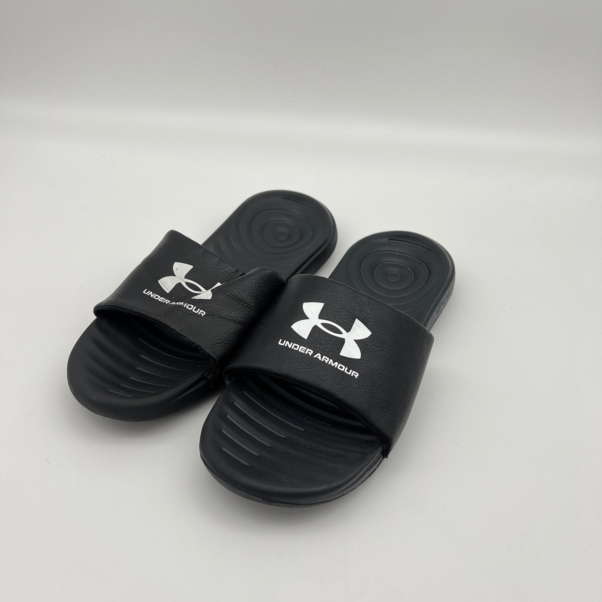 Lightweight black Under Armour sandals with a textured footbed and durable EVA outsole