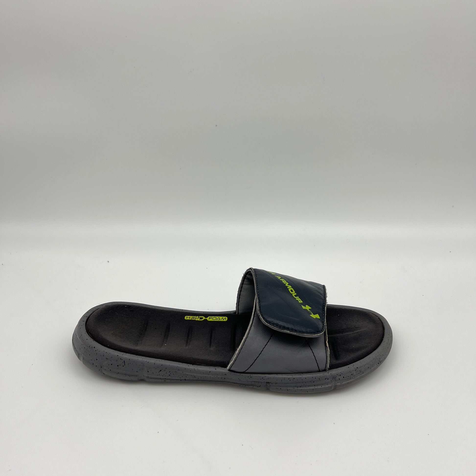 Side view of Under Armour Men's Ignite V slide sandal in gray and black with a speckled sole