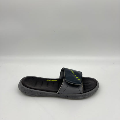 Side view of Under Armour Men's Ignite V slide sandal in gray and black with a speckled sole